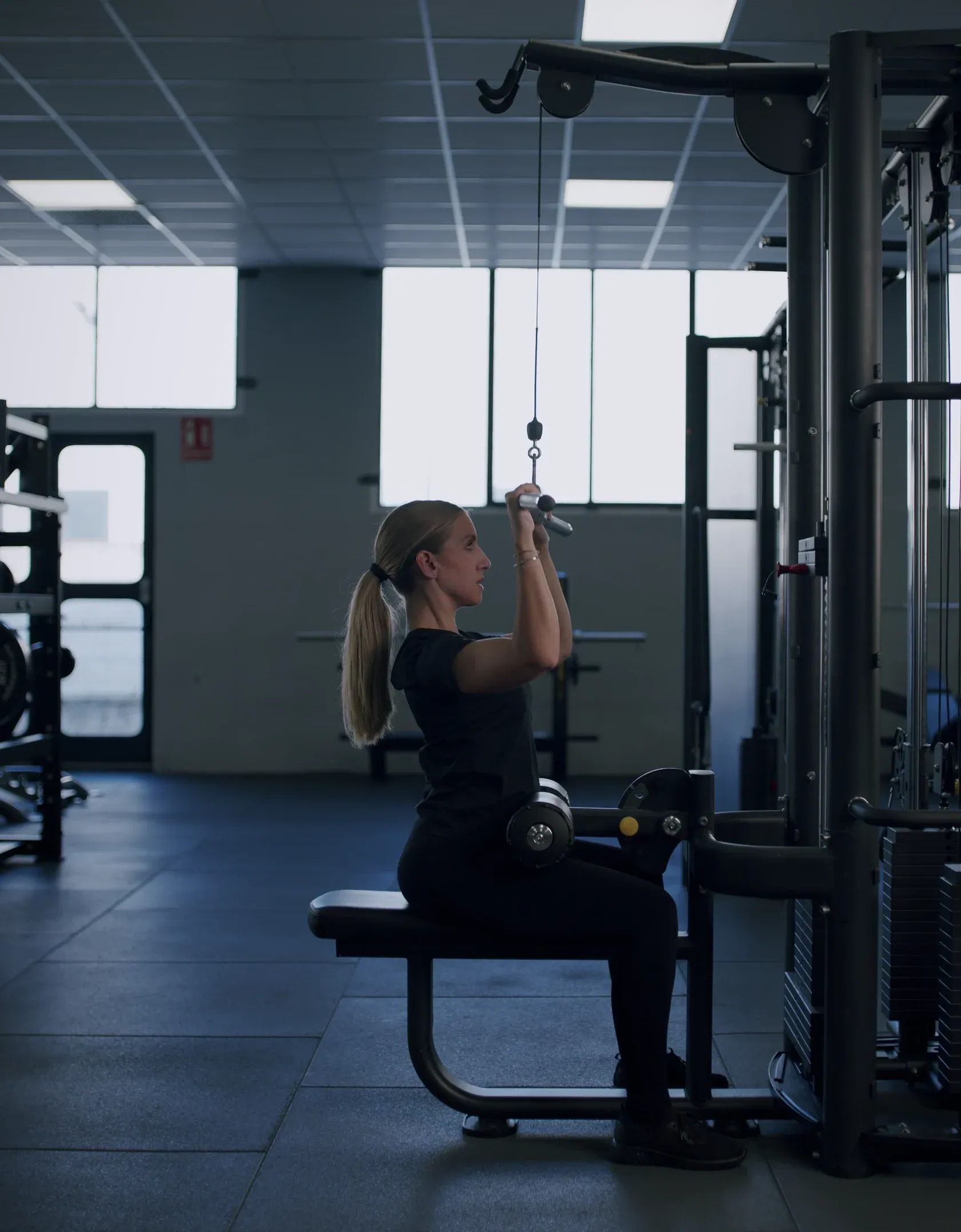 Athlete pulling down on a lat machine in a Mentor partner gym
